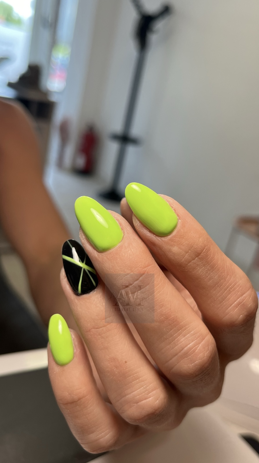 Person mit neon-grünen und schwarz gemusterten Fingernägeln im Raum