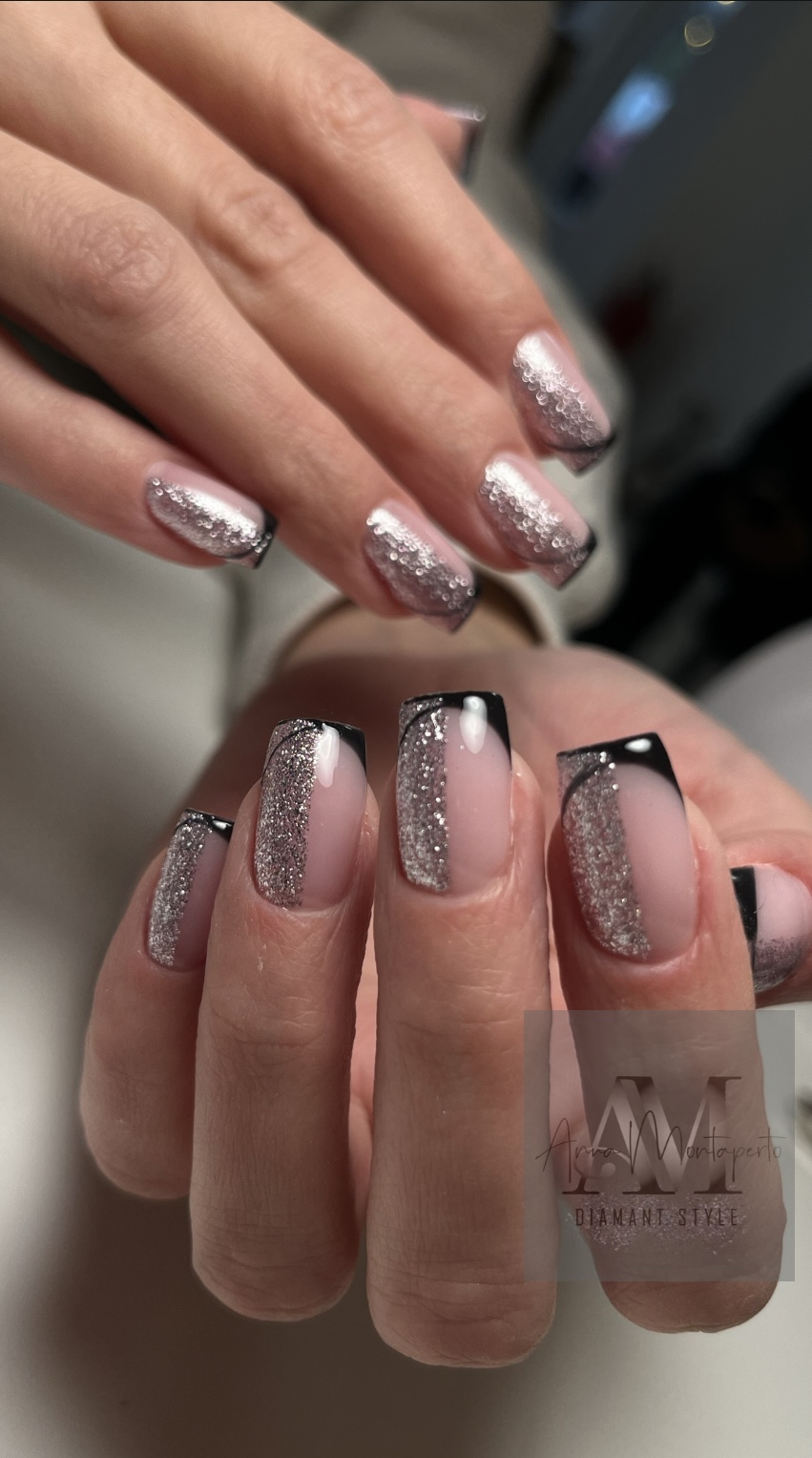 Nahaufnahme von Händen mit elegantem Glitzer-Nageldesign und schwarzem Rand