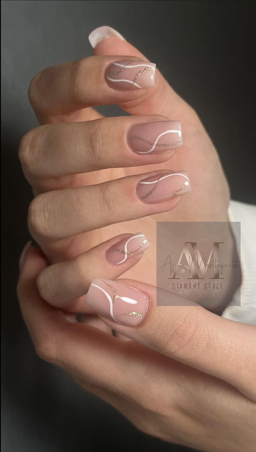 Nahaufnahme von Händen mit elegantem rosa Nageldesign und goldenen Akzenten