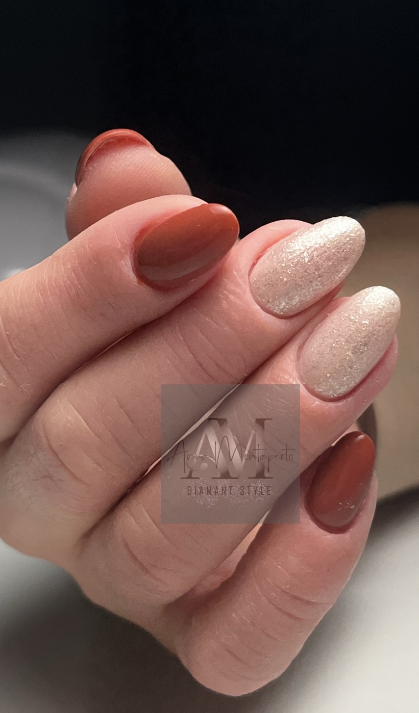 Nahaufnahmemotiv einer Person mit elegant lackierten Fingernägeln in glänzendem Rot und schimmerndem Beige, zeigt feine Handdetails.