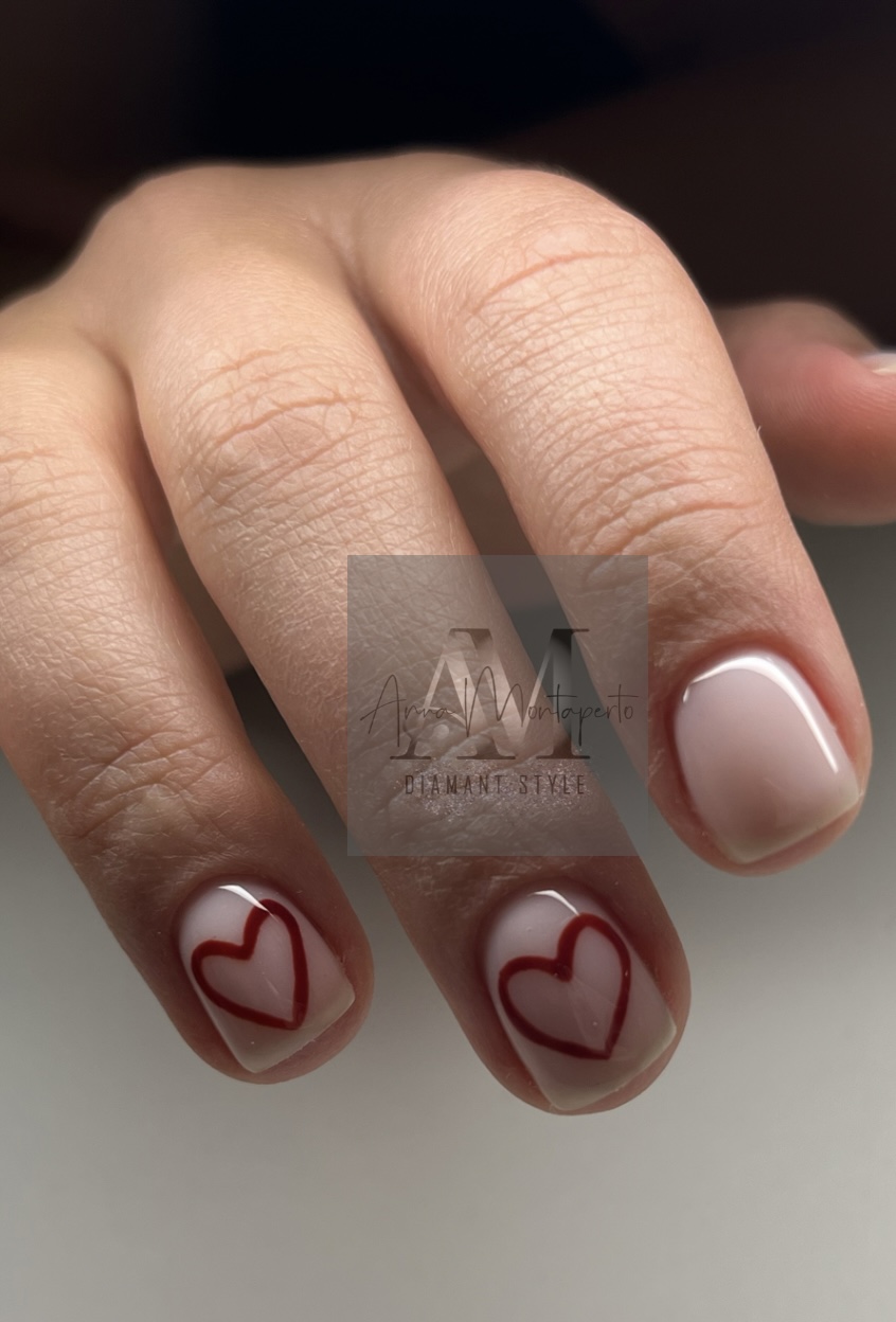 Eine nah aufgenommene Hand mit schlichtem Nageldesign und Herzmotiven.