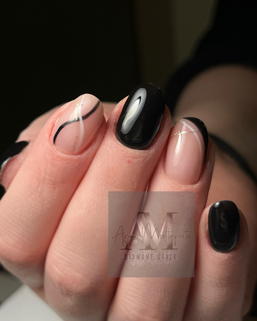 Elegante Hände mit schwarz-weißem Nageldesign und feinem Goldakzent