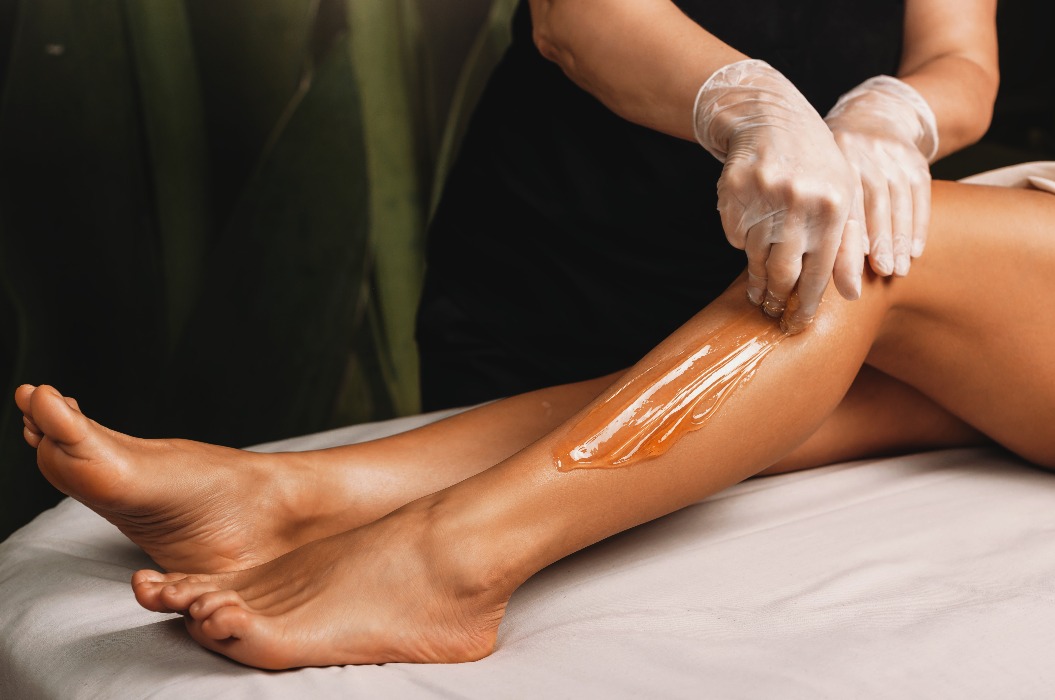 Junges kaukasisches Mädchen bei der Epilation mit Zucker im Spa-Salon